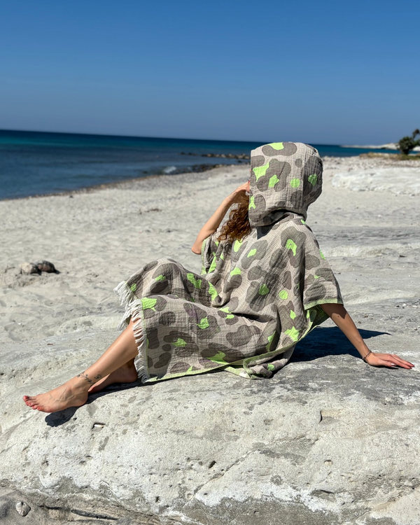 Woman using a Towel to Go Hooded Cotton Beach Poncho in Grey and Lime from the Neon Safari on the beach 2.