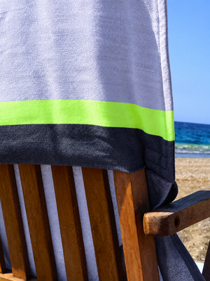 Close-up of the Grey & Charcoal 2-in-1 Beach Towel Bag on a wooden chair by the sea