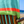 Close-up of the Mint & Lime 2-in-1 Beach Towel Bag on a wooden chair by the sea