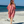 Woman using a Towel to Go Hooded Cotton Beach Poncho in Camel and Rose from the Neon Safari on the beach.