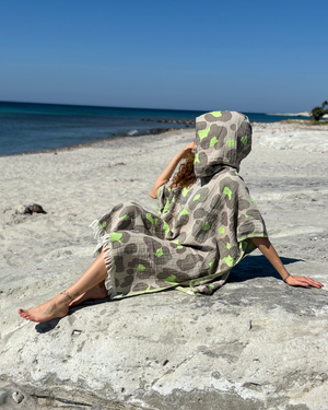 Woman using a Towel to Go Hooded Cotton Beach Poncho in Grey and Lime from the Neon Safari on the beach 2.