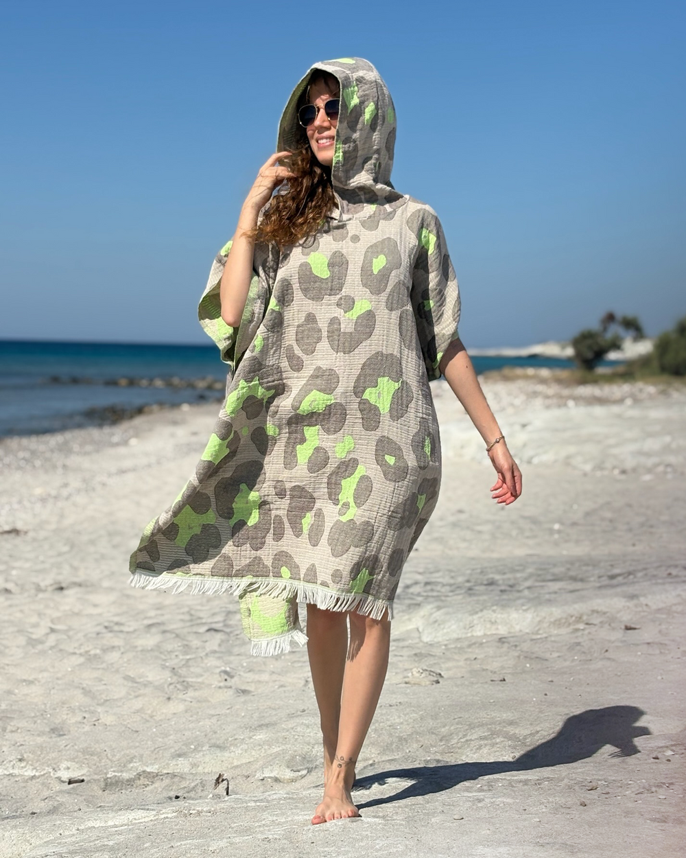 Woman using a Towel to Go Hooded Cotton Beach Poncho in Grey and Lime from the Neon Safari on the beach.