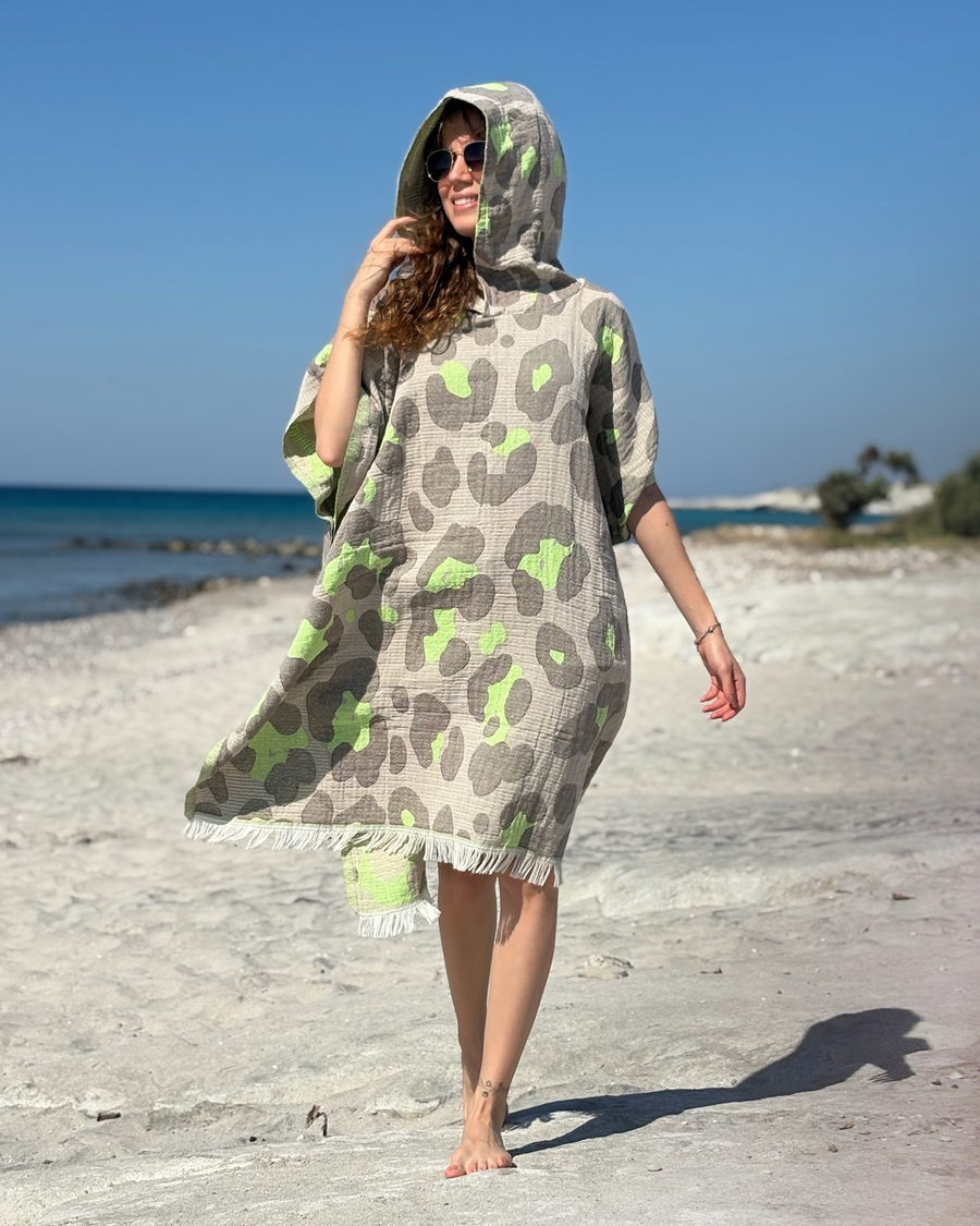 Woman using a Towel to Go Hooded Cotton Beach Poncho in Grey and Lime from the Neon Safari on the beach.