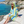 Woman using a Towel to Go Hooded Cotton Beach Poncho in Blue and Lime from the Coral Coast on the beach.