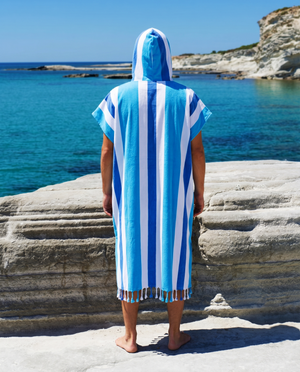 Man using a Towel to Go Hooded Cotton Beach Poncho in Blue and Navy from the Coral Coast on the beach 2.