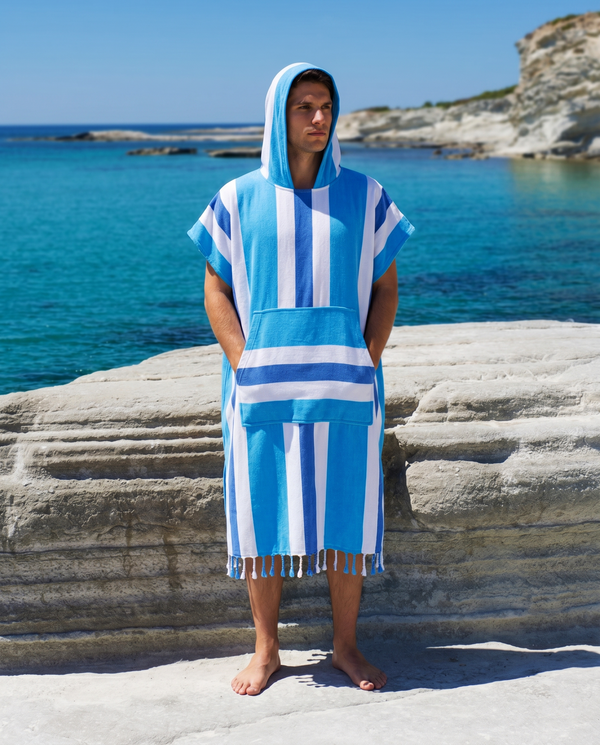 Man using a Towel to Go Hooded Cotton Beach Poncho in Blue and Navy from the Coral Coast on the beach.