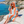 Woman using a Towel to Go Hooded Cotton Beach Poncho in Orange and Mint from the Coral Coast on the beach.
