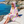 Woman using a Towel to Go Hooded Cotton Beach Poncho in Rose and Sunset from the Coral Coast on the beach.