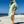Woman using a Towel to Go Hooded Cotton Beach Poncho in Sage and Blush from the Neon Safari on the beach.