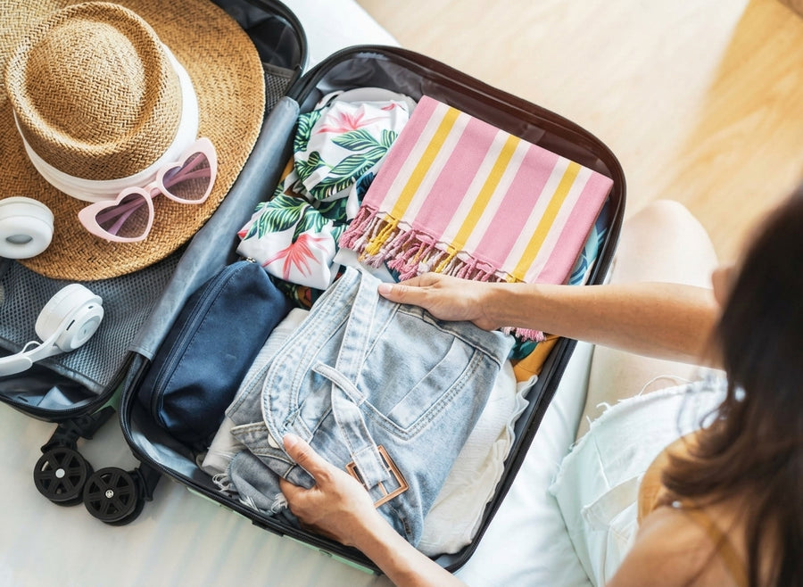 Lightweight quick-dry cotton travel towel packed in a suitcase with summer travel essentials.