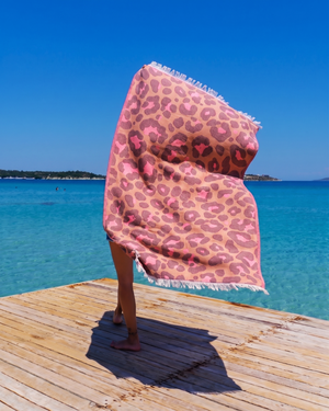 Woman using a Towel to Go Quick Dry Cotton Towel in Camel and Rose from the Neon Safari on the beach 2.
