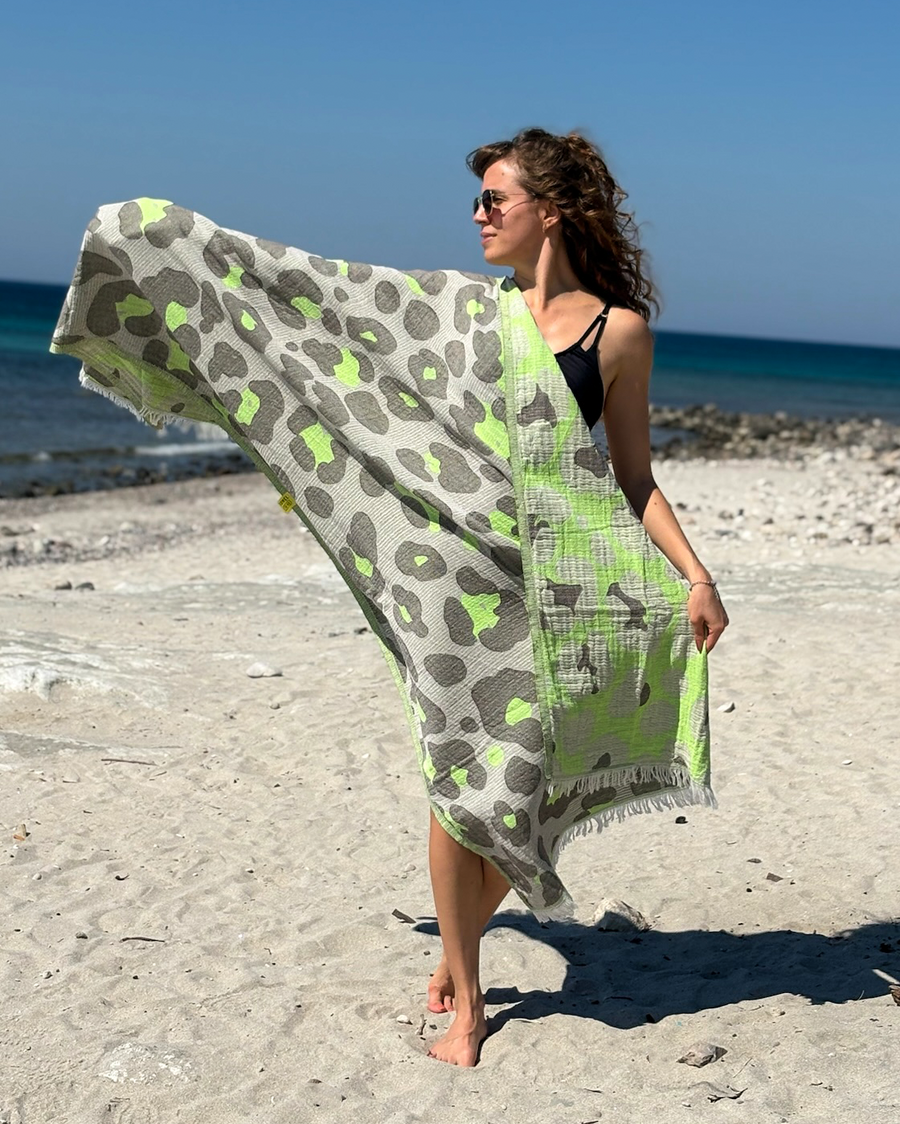 Woman using a Towel to Go Quick Dry Cotton Towel in Grey and Lime from the Neon Safari on the beach.