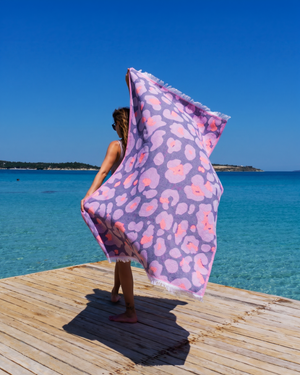 Woman using a Towel to Go Quick Dry Cotton Towel in Lavender and Coral from the Neon Safari on the beach 2.