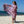 Woman using a Towel to Go Quick Dry Cotton Towel in Lavender and Coral from the Neon Safari on the beach.