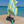 Woman using a Towel to Go Quick Dry Cotton Towel in Lime and Ocean Blue from the Coral Coast on the beach.