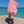 Woman using a Towel to Go Quick Dry Cotton Towel in Orange and Fuchsia from the Coral Coast on the beach.