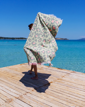 Woman using a Towel to Go Quick Dry Cotton Towel in Sage and Blush from the Neon Safari on the beach 2.