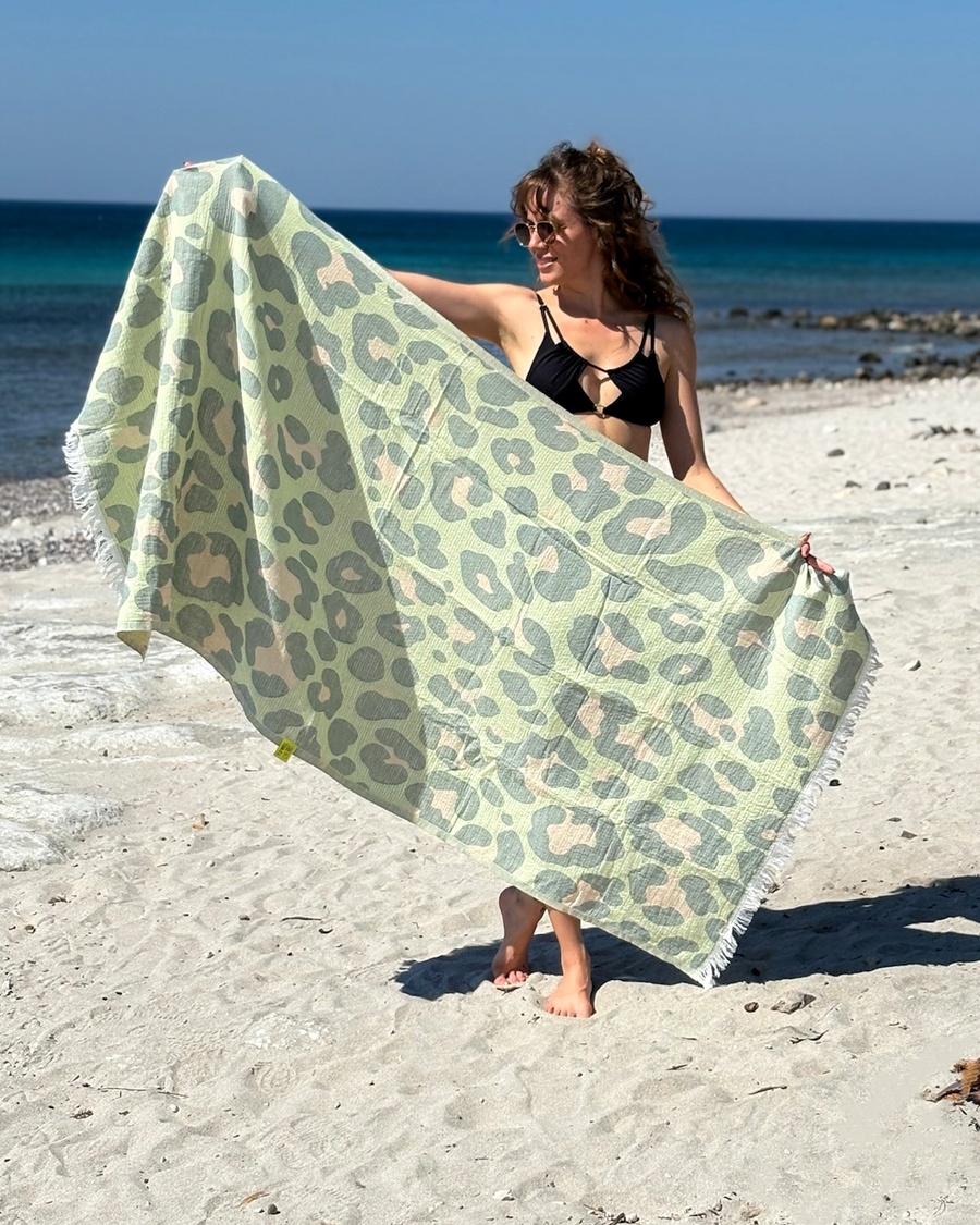 Woman using a Towel to Go Quick Dry Cotton Towel in Sage and Blush from the Neon Safari on the beach.